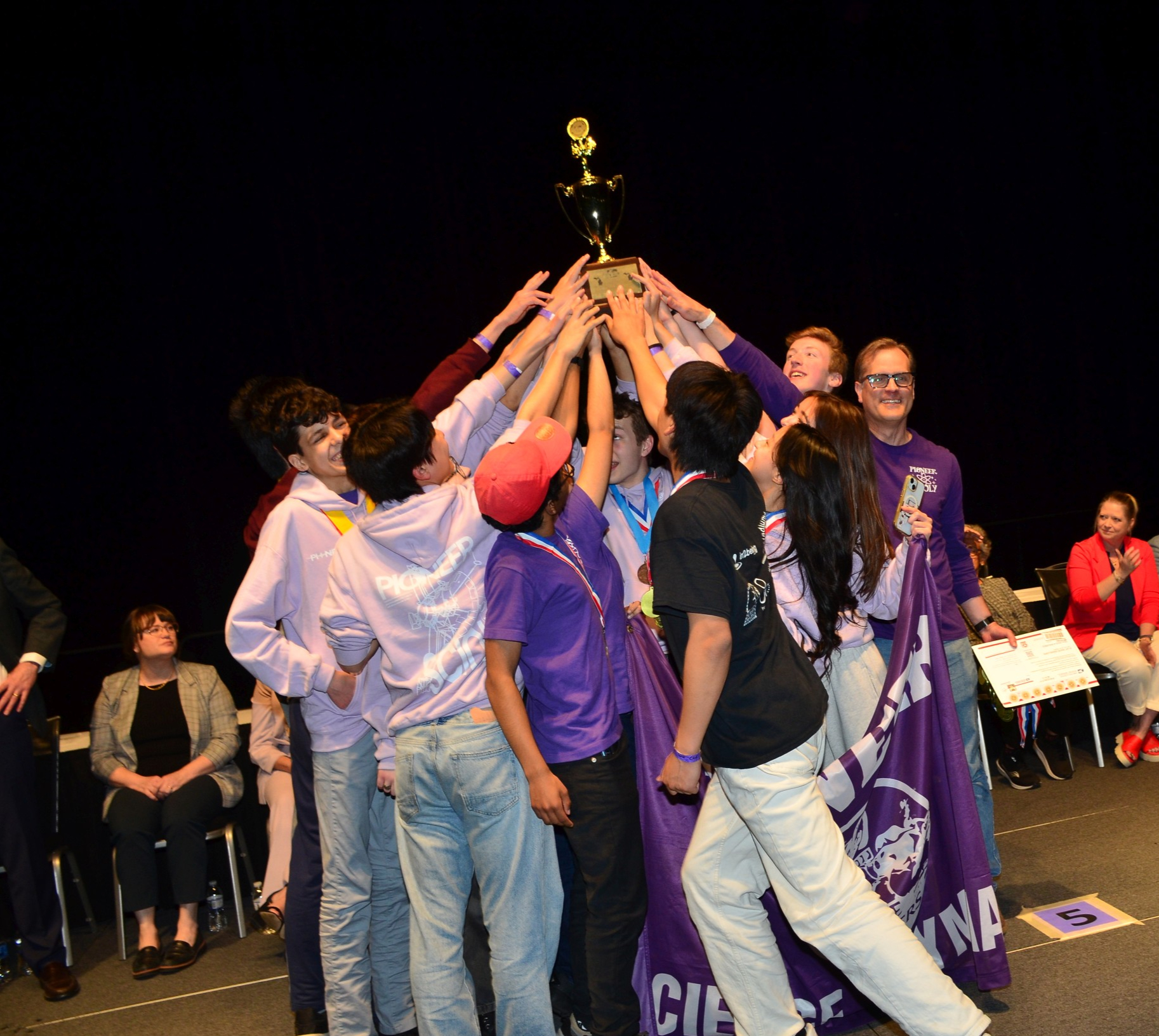 Pioneer Science Olympiad students holding awards at a tournament.